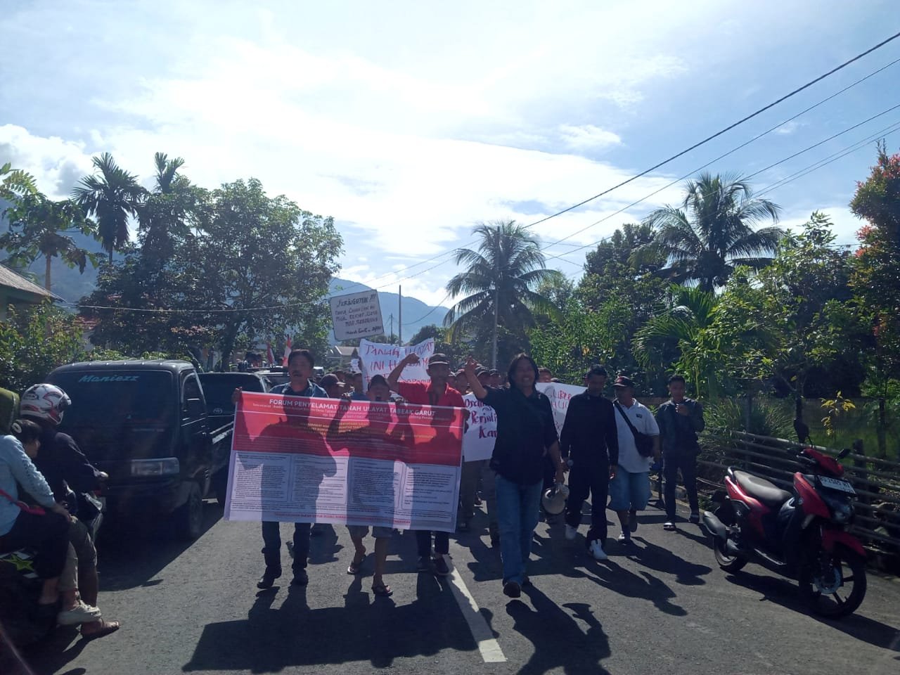 Ratusan warga yang tergabung dalam Forum Masyarakat Adat Taba Seberang menggelar aksi penolakan pembangunan Gedung Koperasi Merah Putih di lapangan sepak bola Desa Garut, Kecamatan Amen, Senin (16/2/2026) pagi.